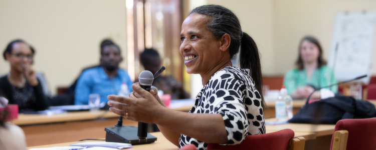 Woman talking in front of a group of people. Foto: @ Camilla Zilo