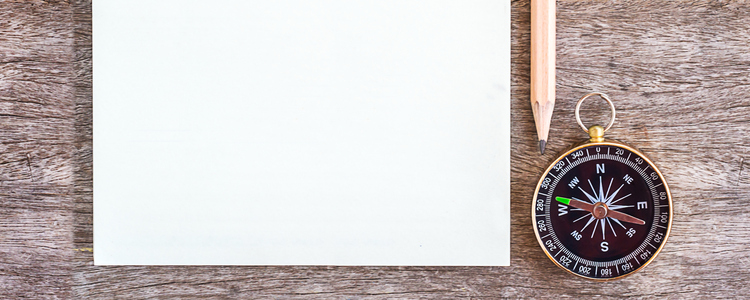 Open blank notebook with pencil and compass over a wooden background. Top View.