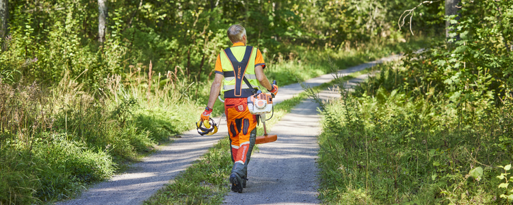 Man som går på skogsväg med röjsåg i handen. Foto: Patrik Svedberg