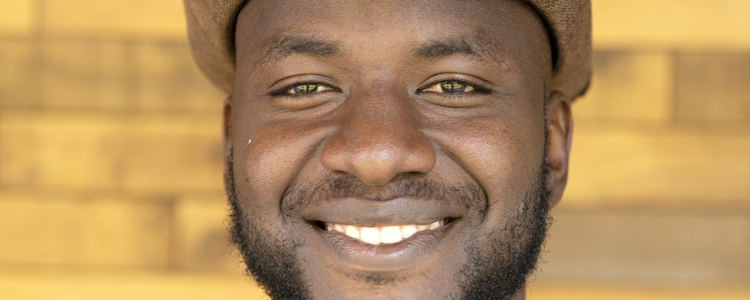Man with a hat smiling. Foto: @ Camilla Zilo