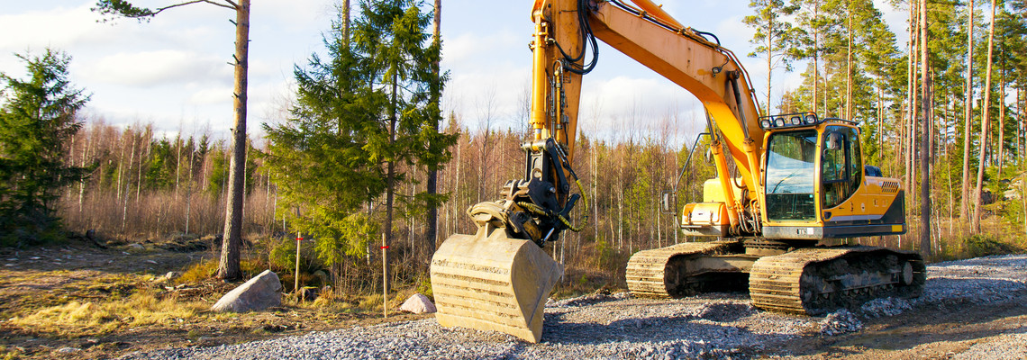 En grävmaskin vid ett påbörjat byggande av skogsbilväg. Foto: Adobe Stock