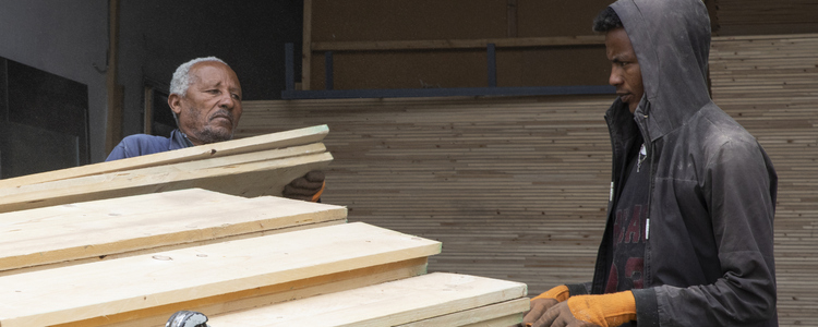 Two men loading timber onto a truck. Foto: @ Camilla Zilo