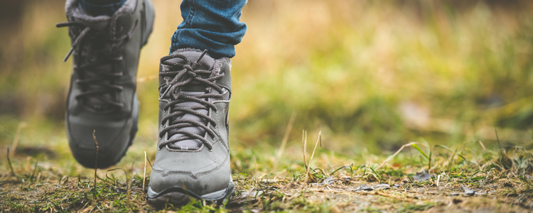 person med kängor som går i en skog. Foto: Mostphotos