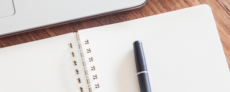 Notepad and laptop on wood table, stock photo. Foto: AuM